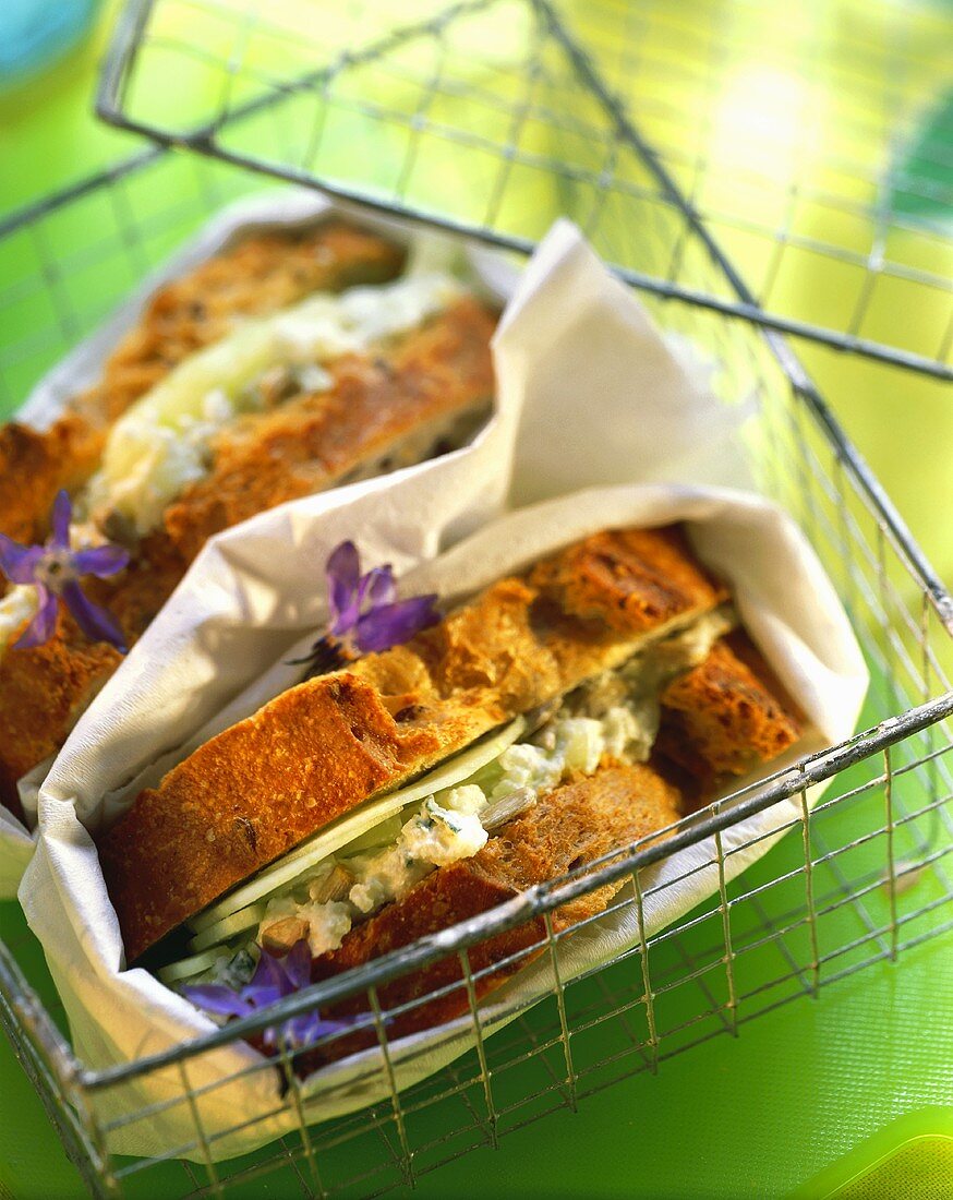 Goat's cheese sandwich with cucumber & borage in wire basket