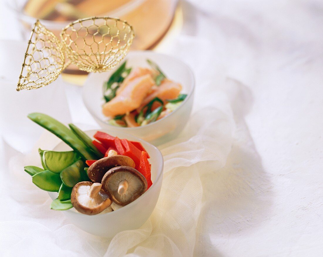 Fondue chinoise mit rohem Gemüse und Lachs in Schälchen