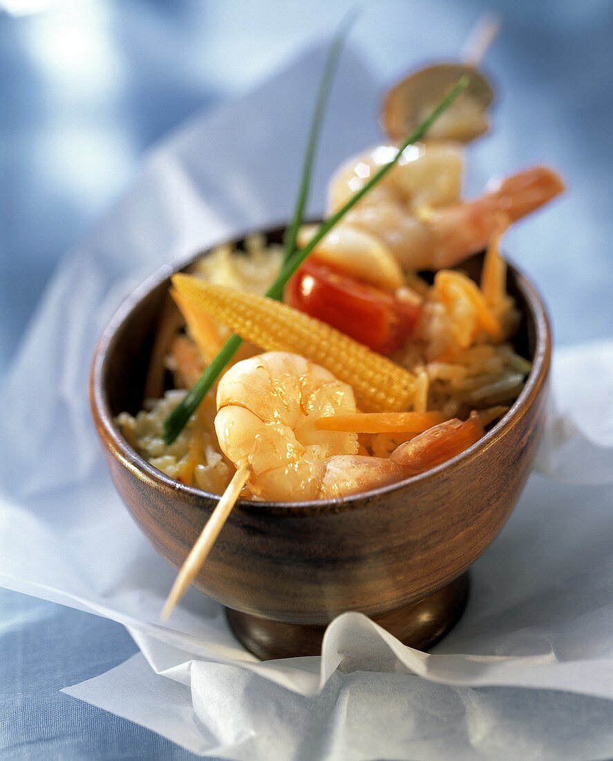 Shrimp kebabs with corncobs on rice in wooden bowl