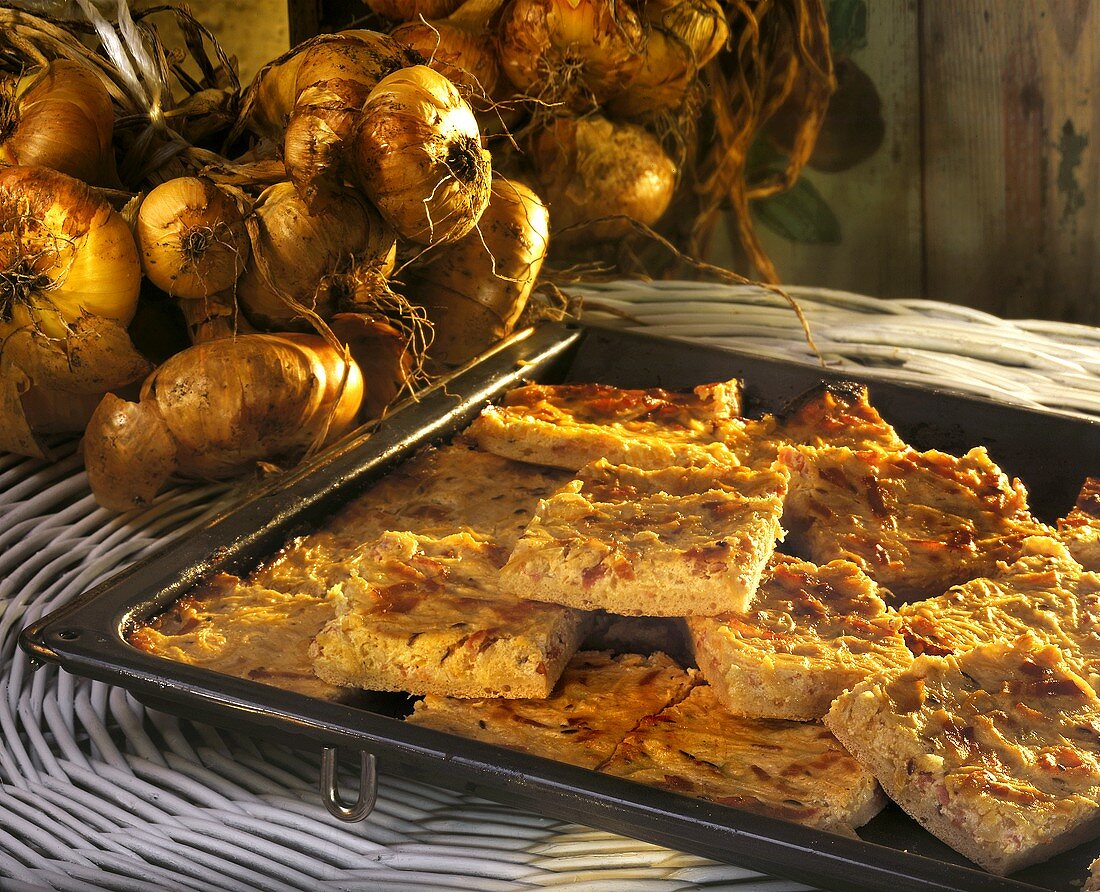 Onion cake, cut into pieces, on a baking sheet