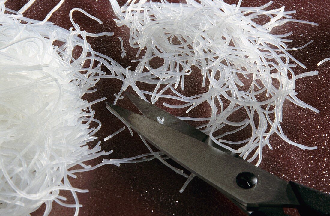 Chopping glass noodles with scissors