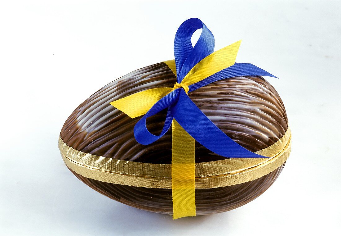 Osterei aus Schokolade mit gelbblauer Schleife