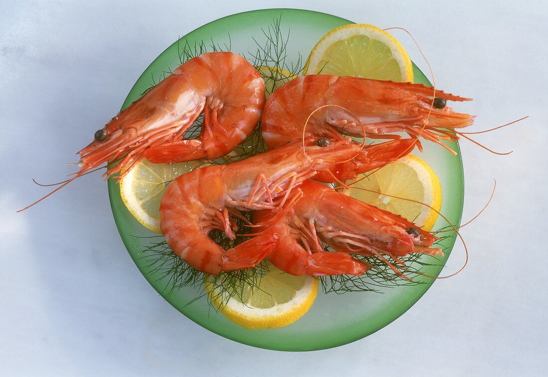 Boiled shrimps with slices of lemon on plate
