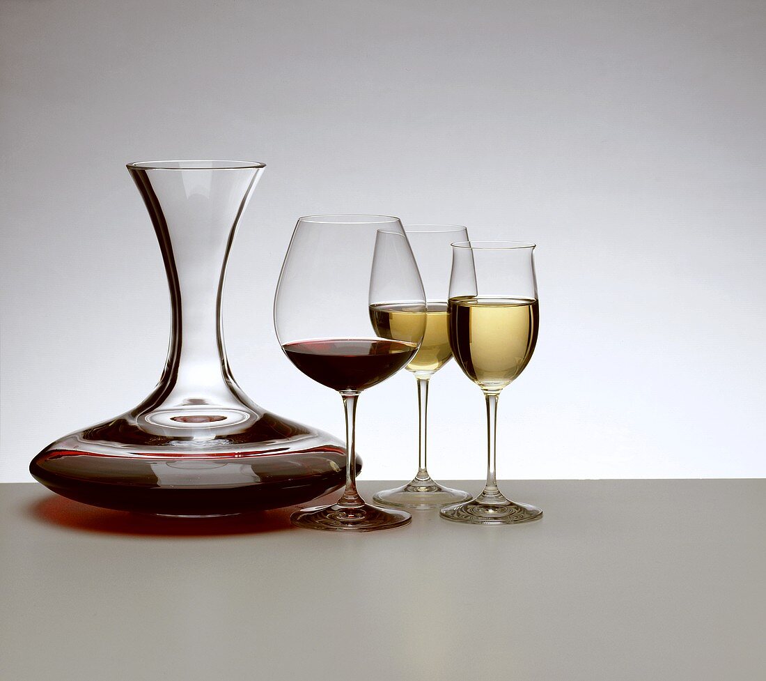 Rotwein und Weißwein, dekantiert, in Gläsern und Karaffe