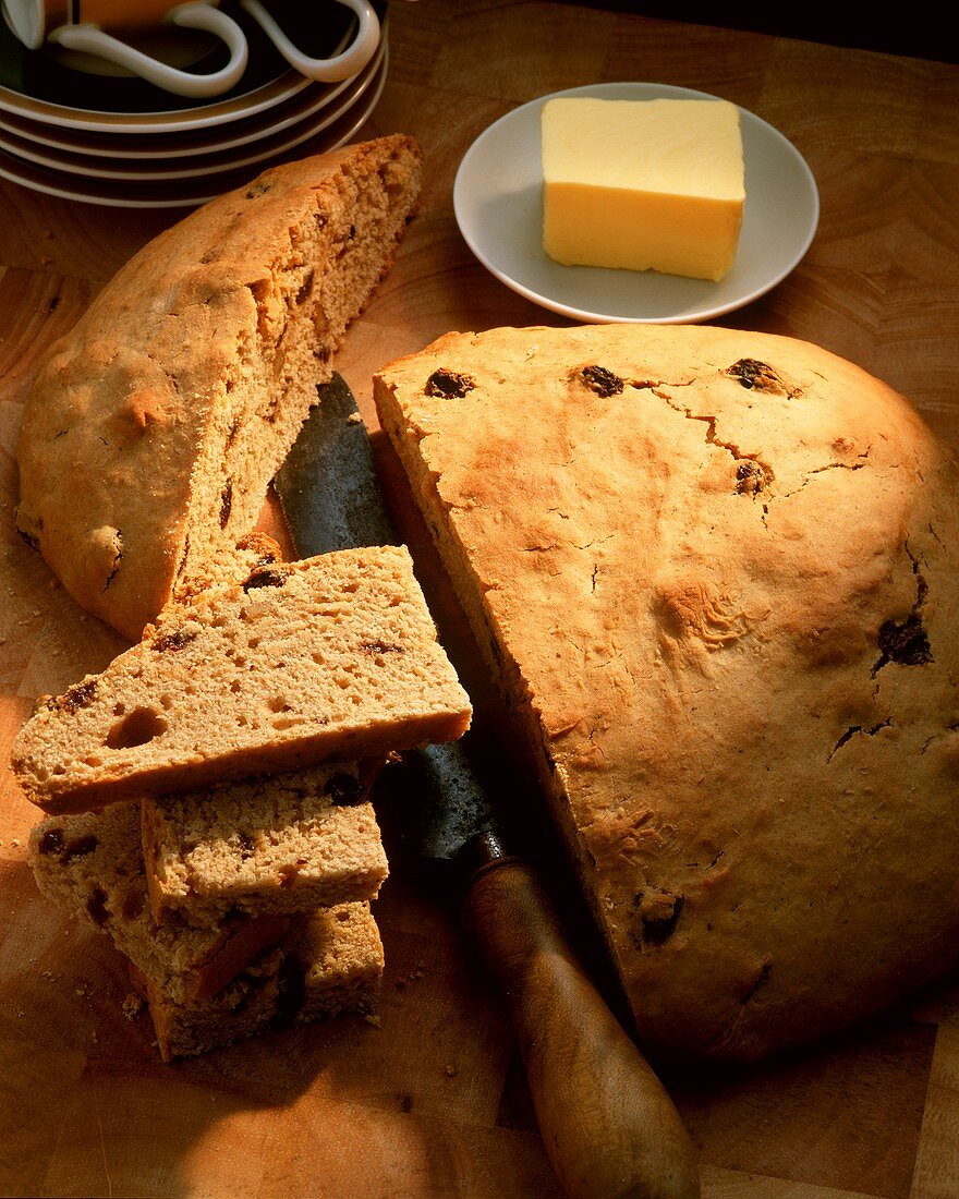 Raisin bread, a slice cut; knife; butter
