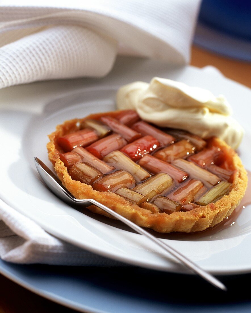 Rhubarb tartlet with cream on plate
