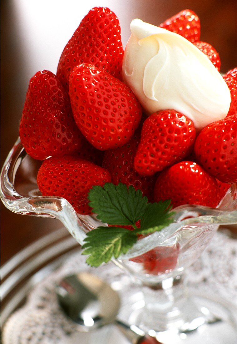 Frische Erdbeeren mit Sahne in einer Glasschale