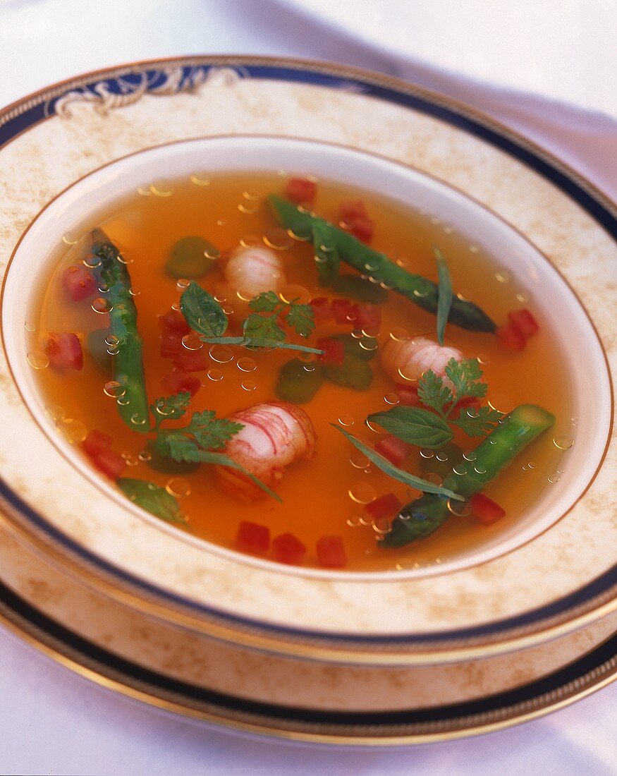 Crab soup with asparagus, diced tomatoes and fresh herbs
