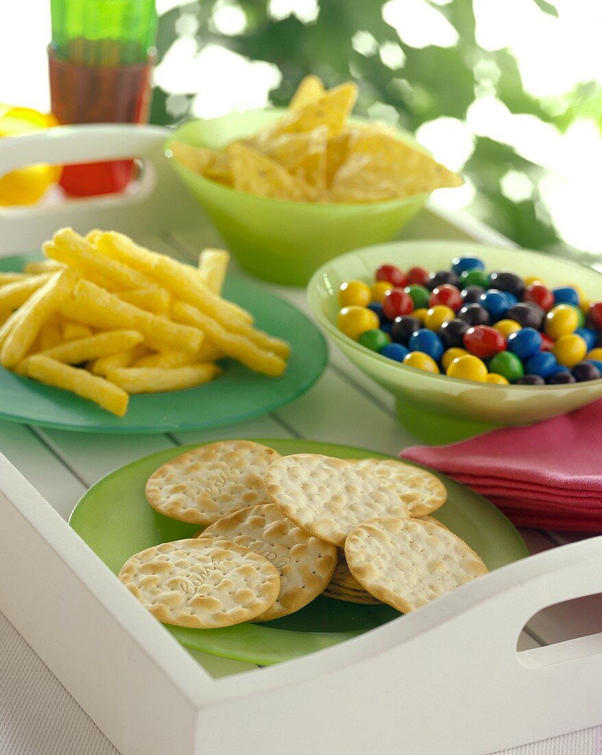 Cracker, chips, crisps and sweets on a tray