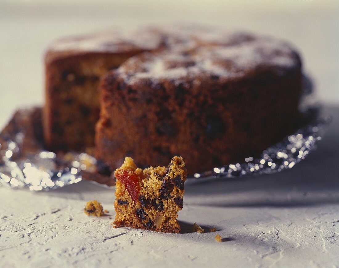 Fruit cake on foil and a small piece of cake in front