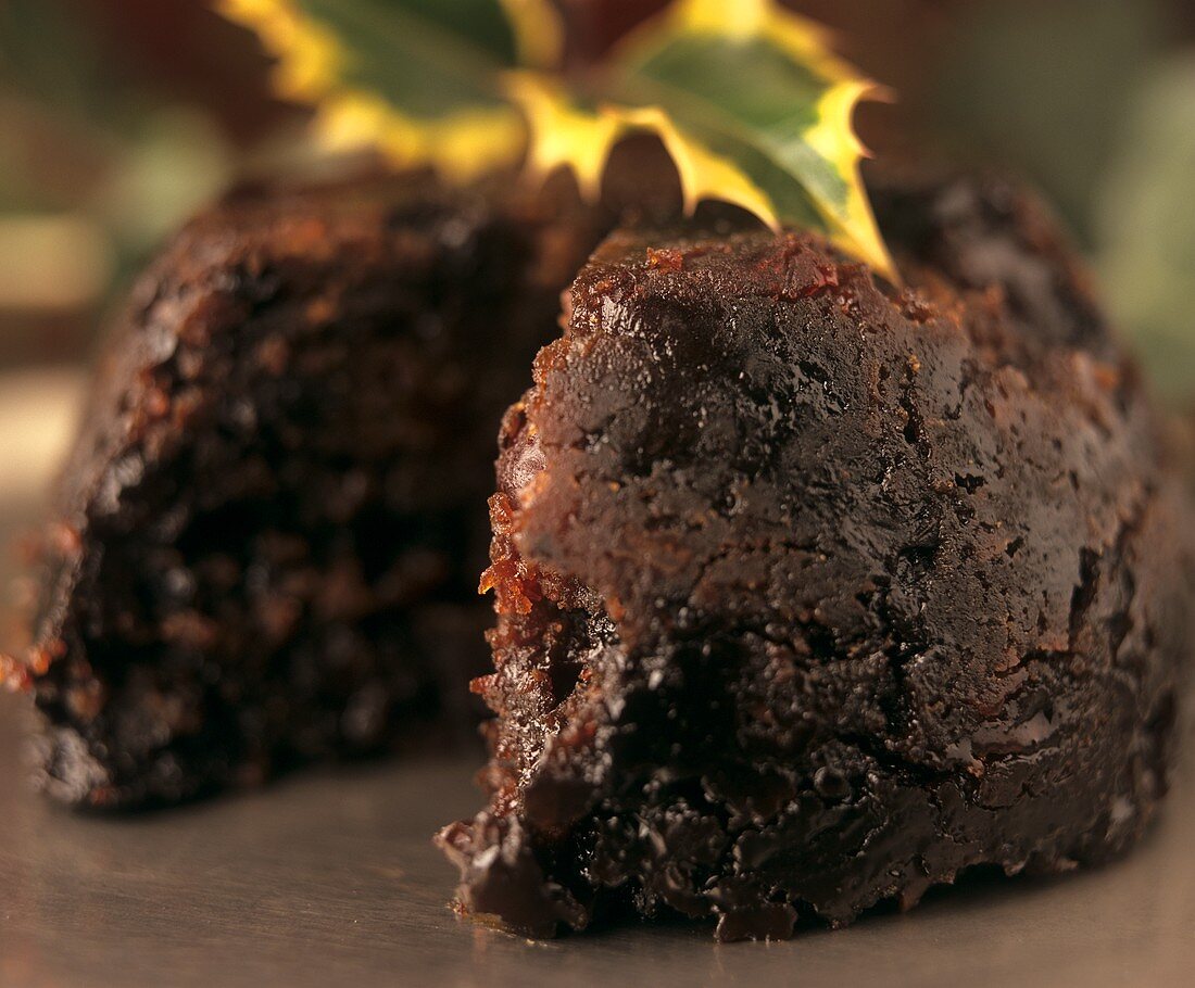 Christmas pudding, piece cut; decoration: sprig of holly