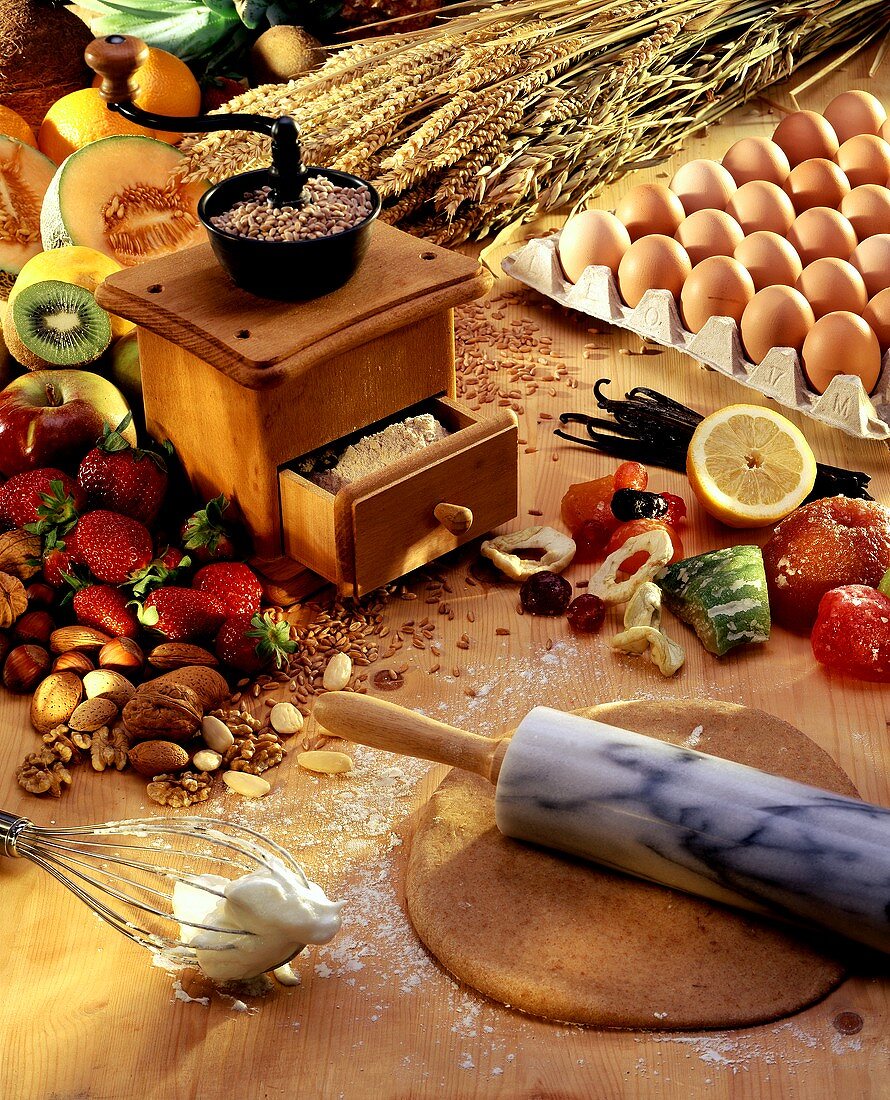 Baking still life with old grain mill, pastry, fruit, eggs etc.
