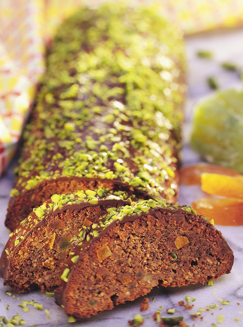 Chocolate roll (Rehrücken) with chopped pistachios (slices cut)
