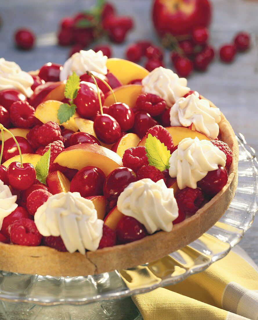 Colourful fruit tart with cream rosettes & lemon balm leaves