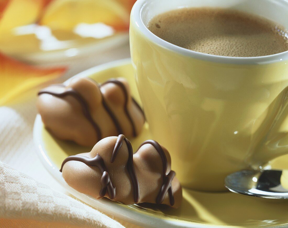 Double nut chocolates on saucer of an espresso cup