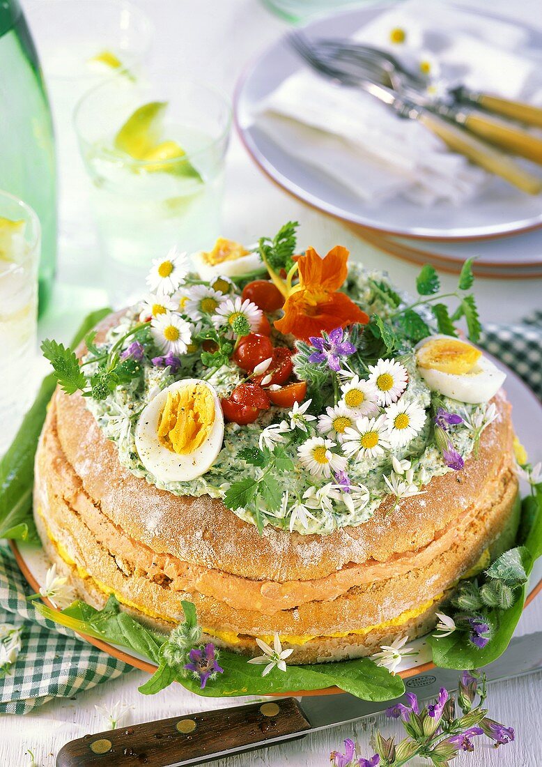 Wild herb cheesecake with edible flowers, eggs, tomatoes