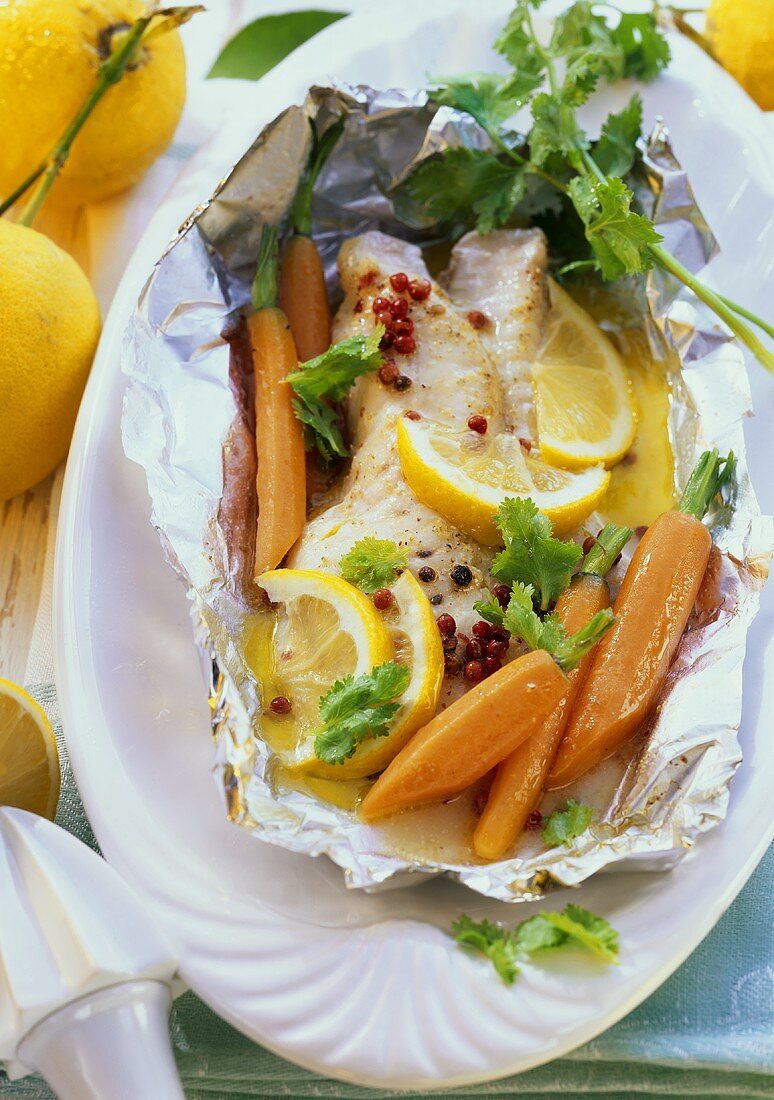 Fish in foil with carrots, pink pepper, lemon, coriander