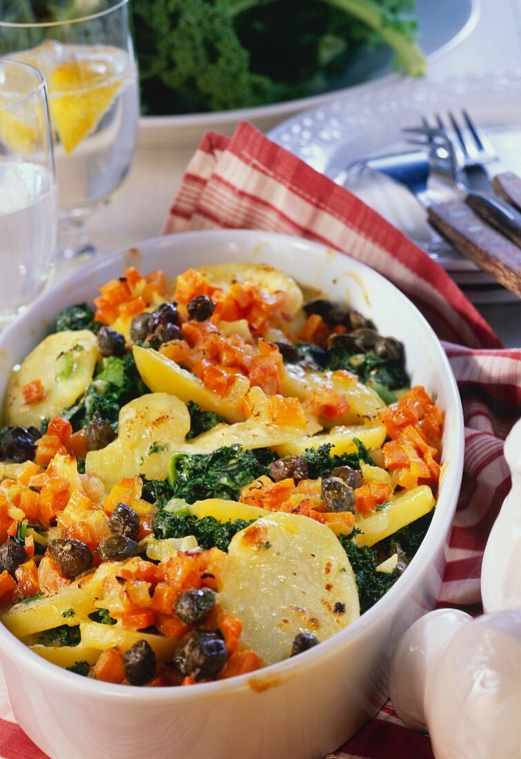 Kale & potato bake with carrots and capers in baking dish