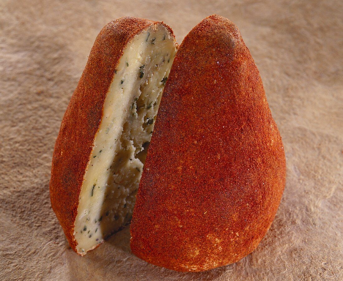 Kegelförmiger Käse Boulette d'Avesnes auf braunem Untergrund