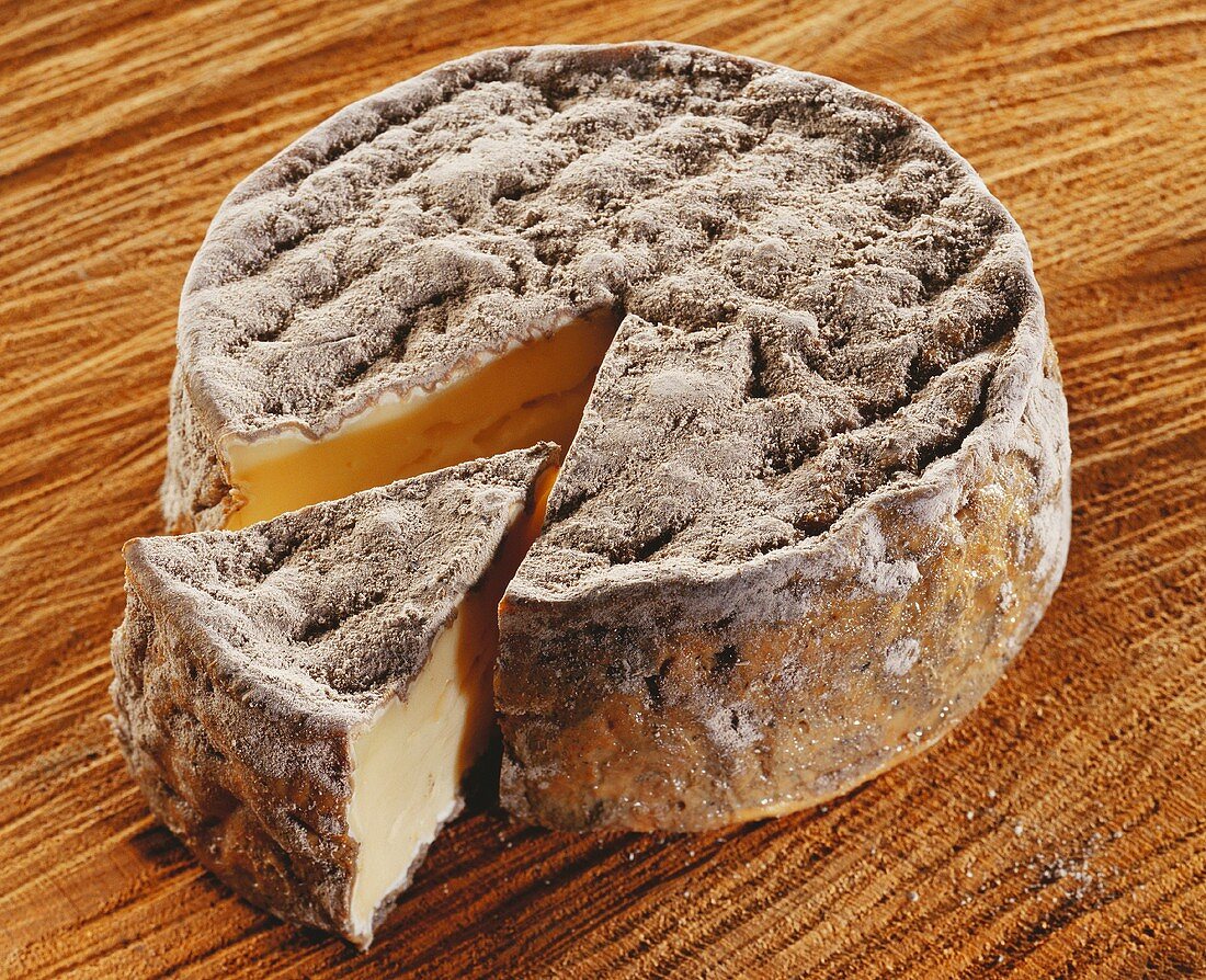 Aisy cendre, a French soft cheese,  cut into