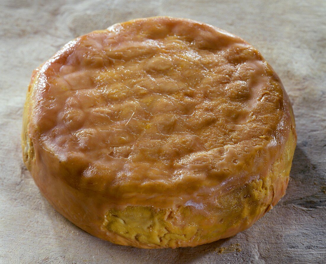 French Epoisses cheese on a light brown background