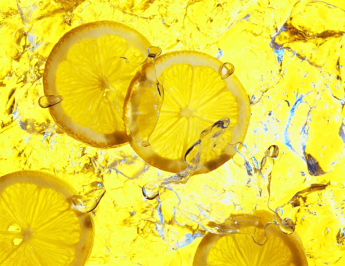 Zitronenscheiben, umgeben von Wasser und Eis