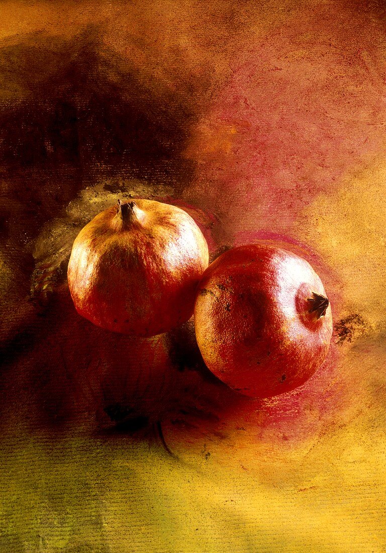 Zwei Granatäpfel auf bemaltem Untergrund