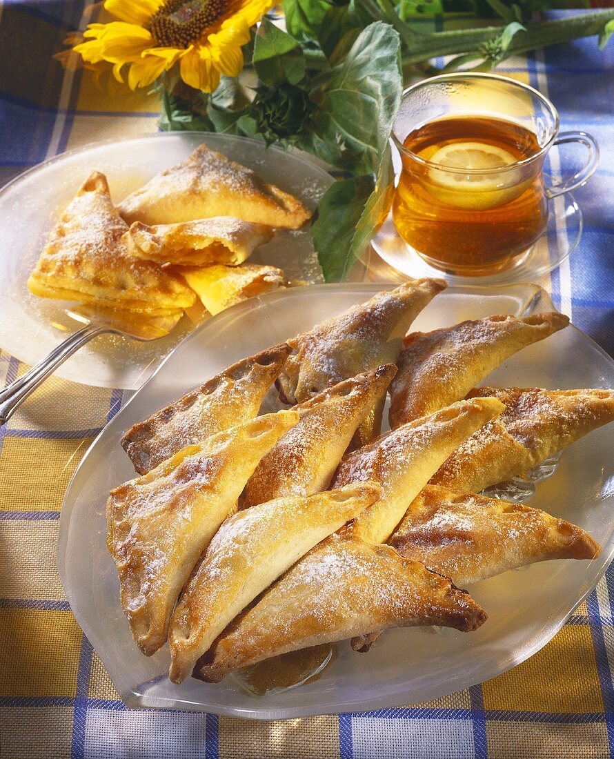Apricot pasties with icing sugar; tea