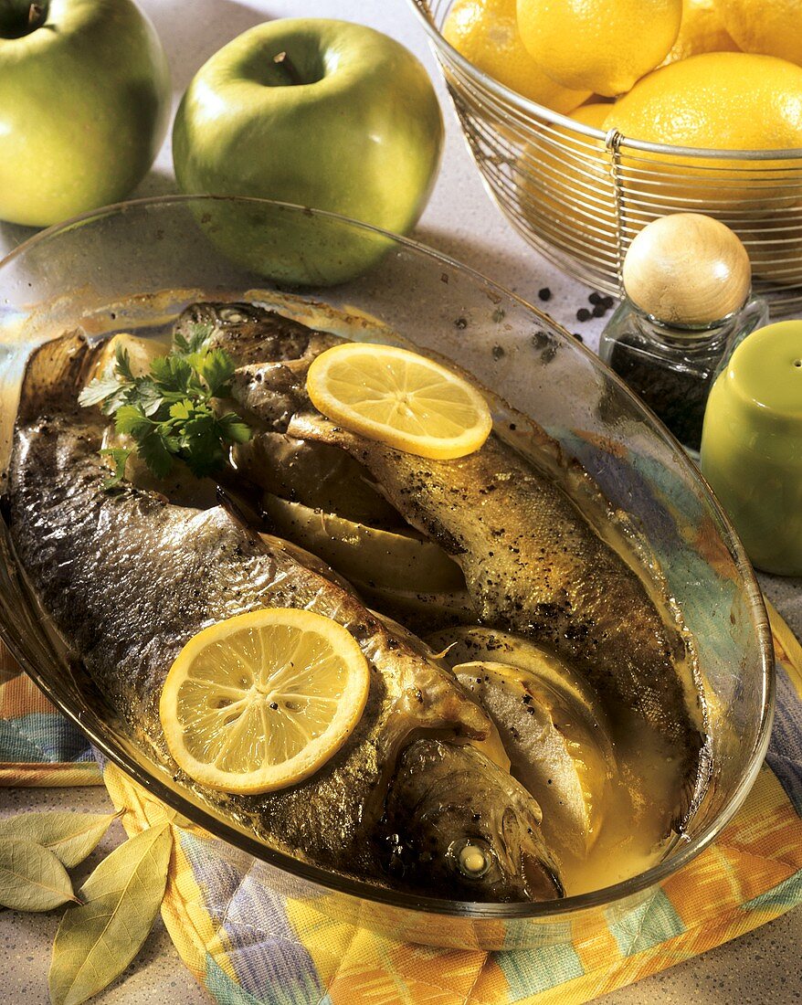 Fried trout with apples and lemon slices