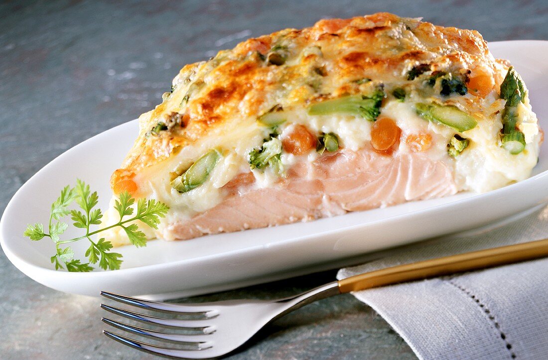Salmon on bed of vegetables & asparagus on white platter