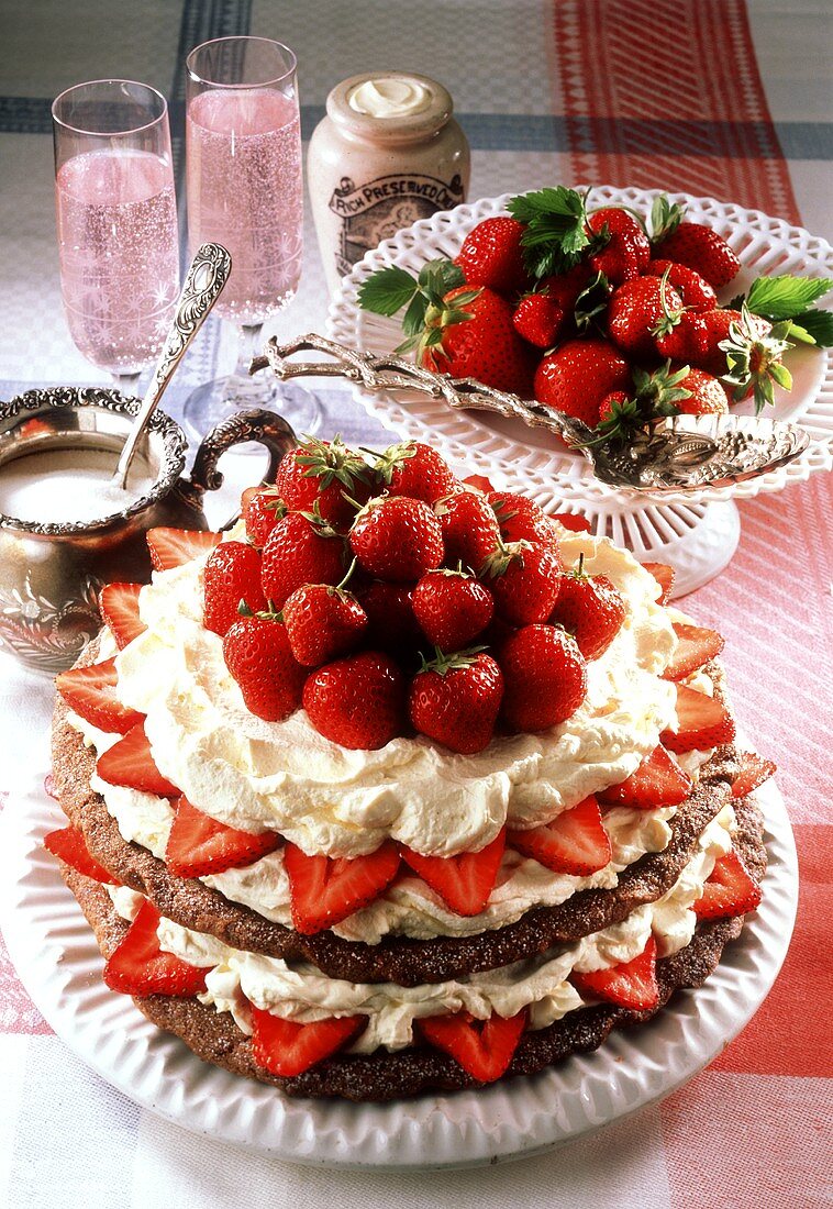 Schichttorte mit Erdbeeren, Sahne und braunem Baiser