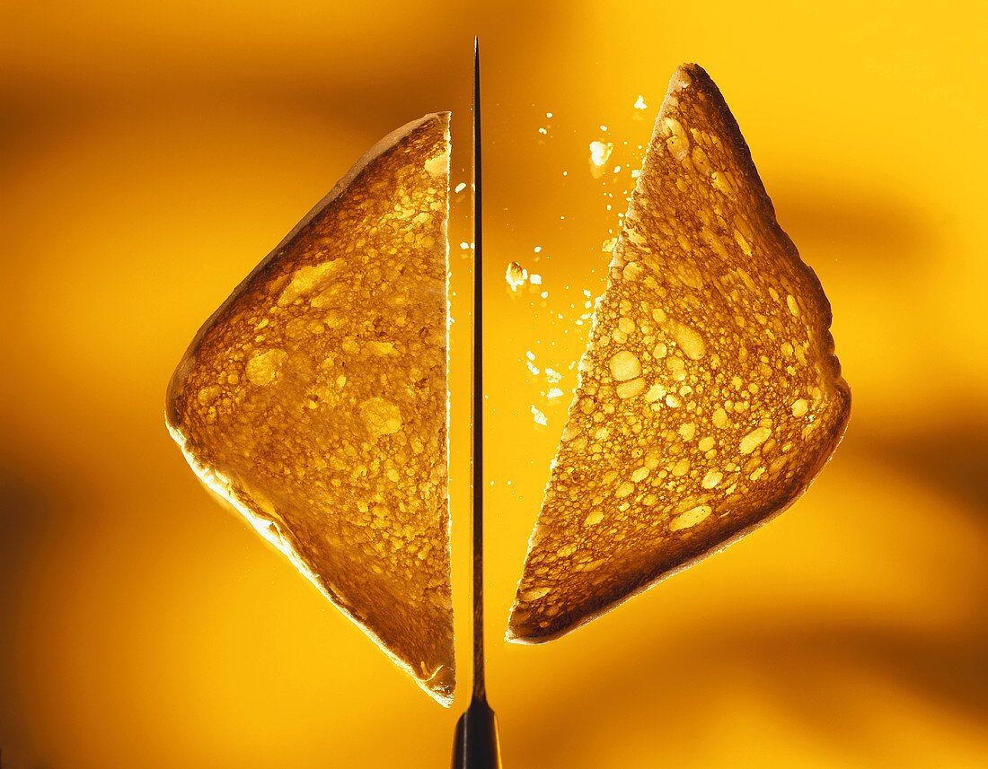 Two triangles of toast with a knife