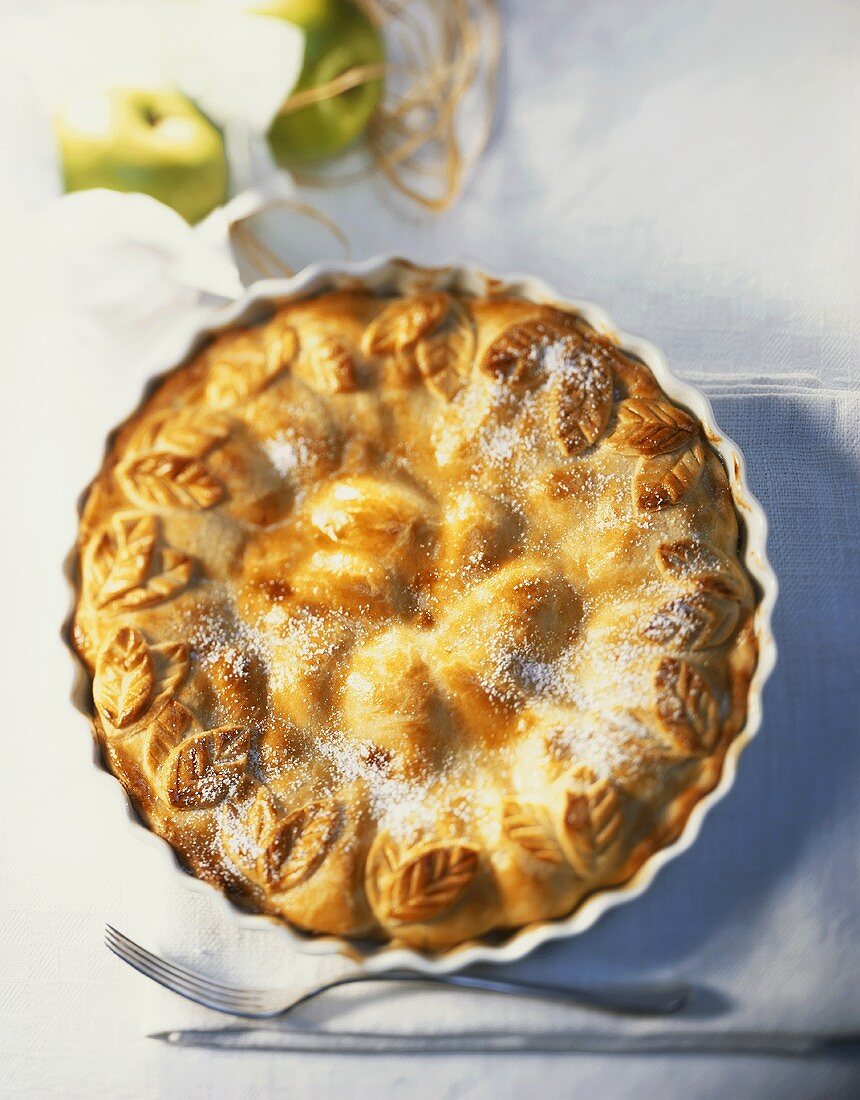 Apple pie, sprinkled with sugar, in pie dish