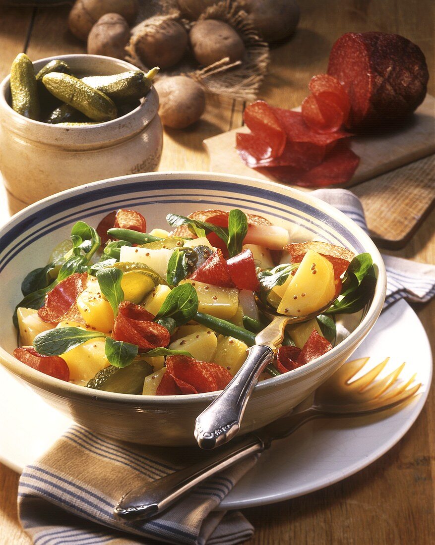 Potato salad with cucumber, salami and corn salad