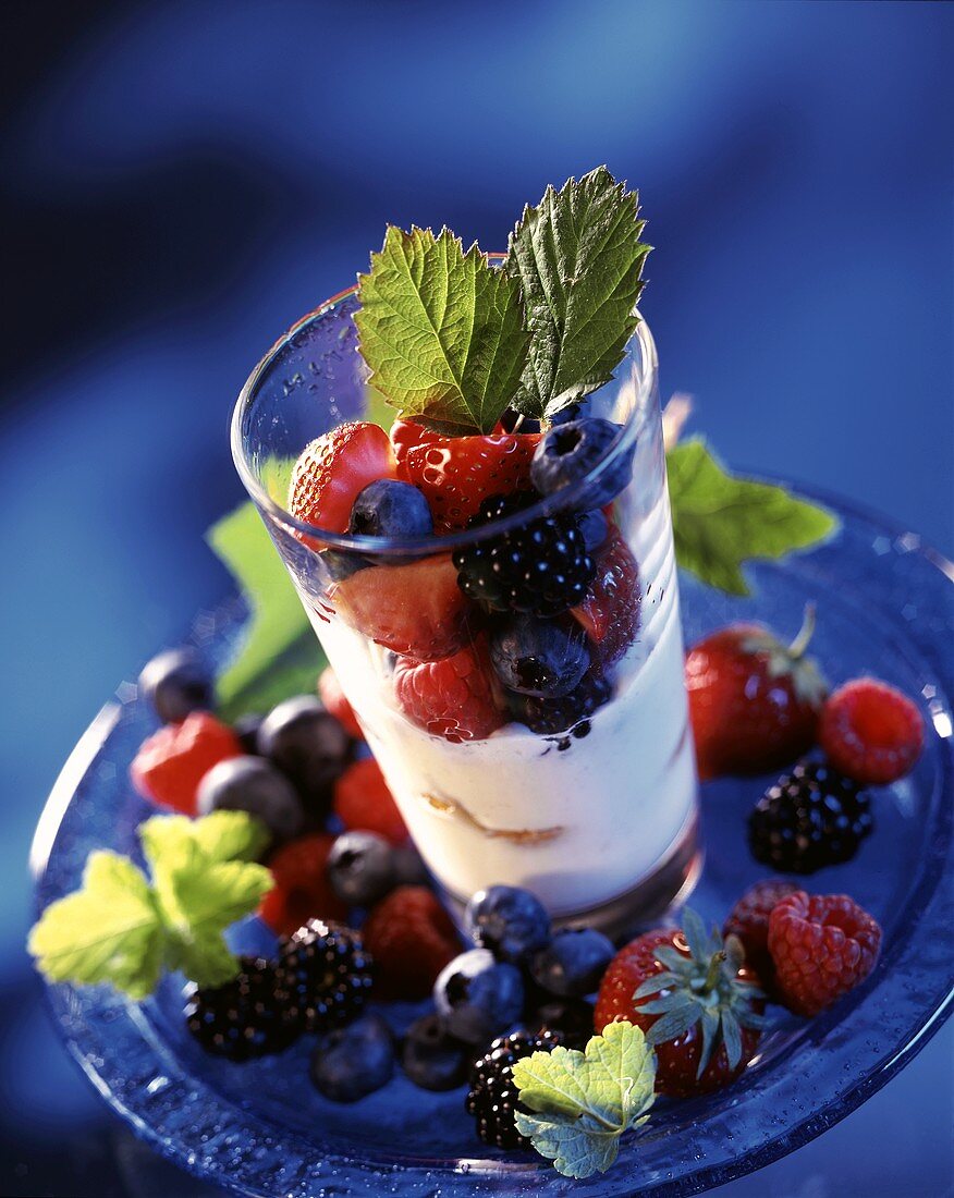 Mascarpone mousse with berries in a glass; blue backdrop