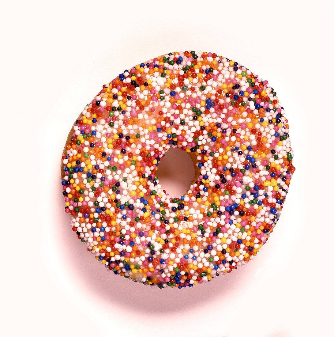 Doughnut with coloured sugar pearls on white background