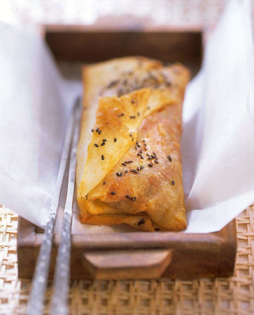 Pike-perch in batter with sesame on tray with chopsticks