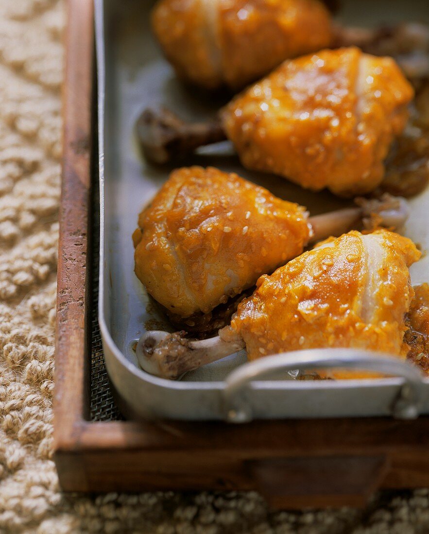 Exotic chicken thighs with sesame in roasting dish