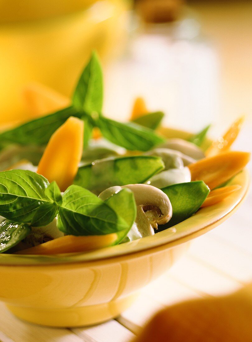 Vegetables with basil dressing in yellow bowl