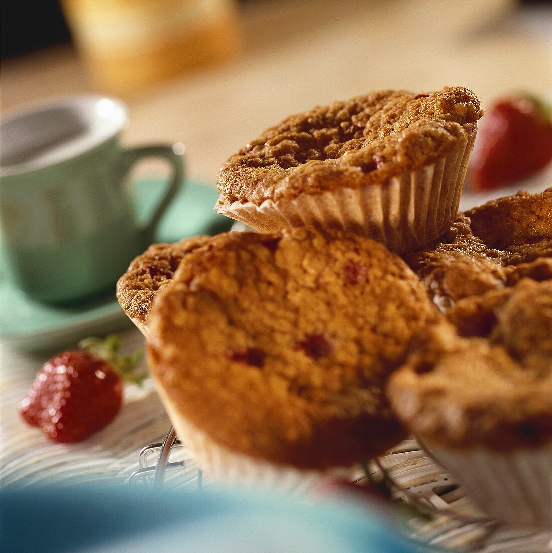 Strawberry muffins on cake rack; coffee cup