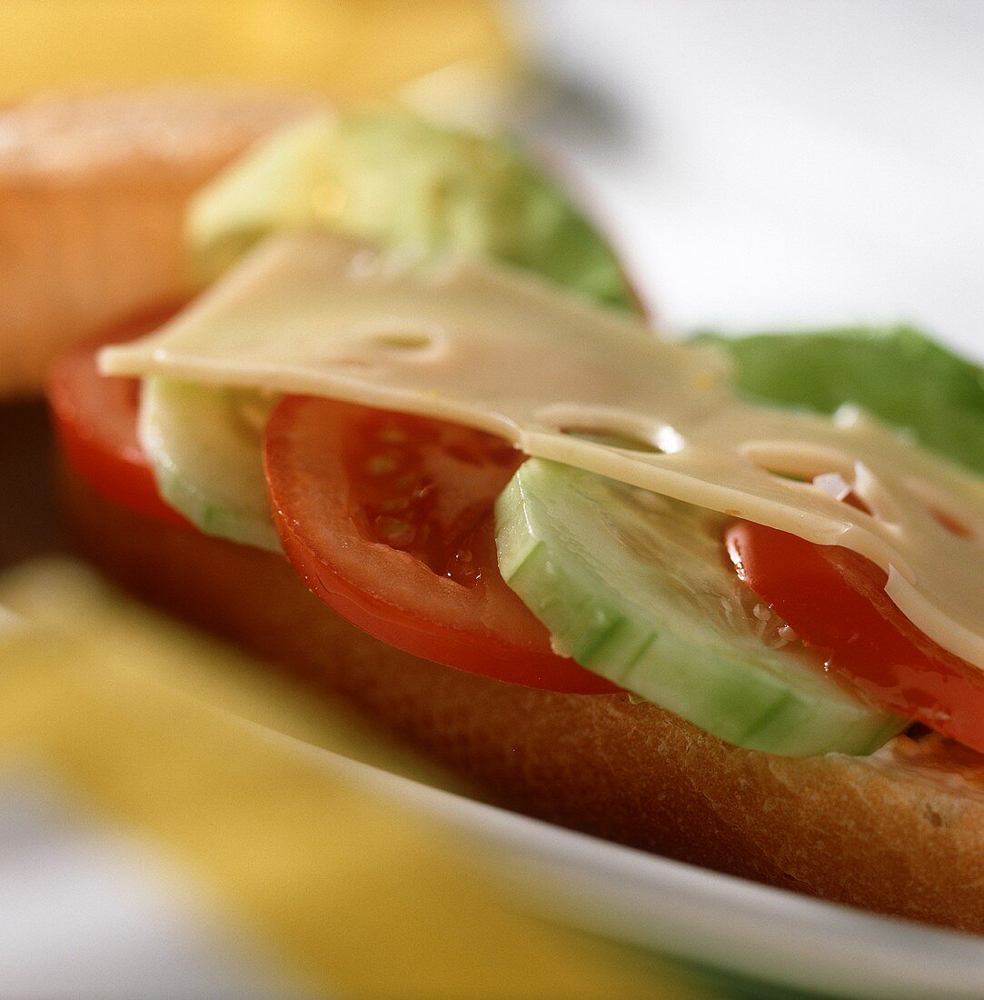 Baguette roll with cheese, tomatoes and cucumber