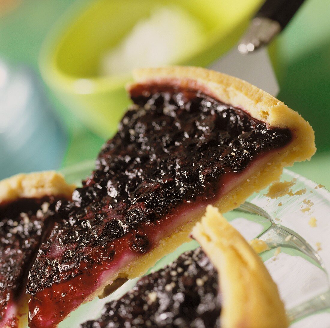 Heidelbeerkuchen mit Guss auf Teller und Kuchenheber