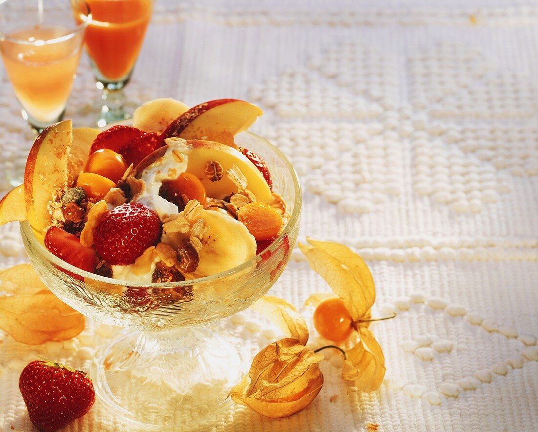 Muesli for dietary fibre with fruit & yoghurt in glass bowl
