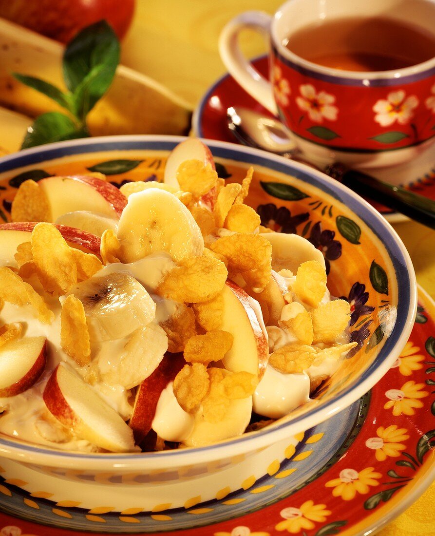 Fruit salad with yoghurt and flakes; teacup