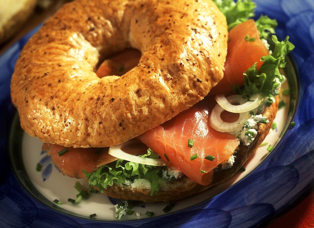 Bagel with salmon, onions, soft cheese and lettuce leaf