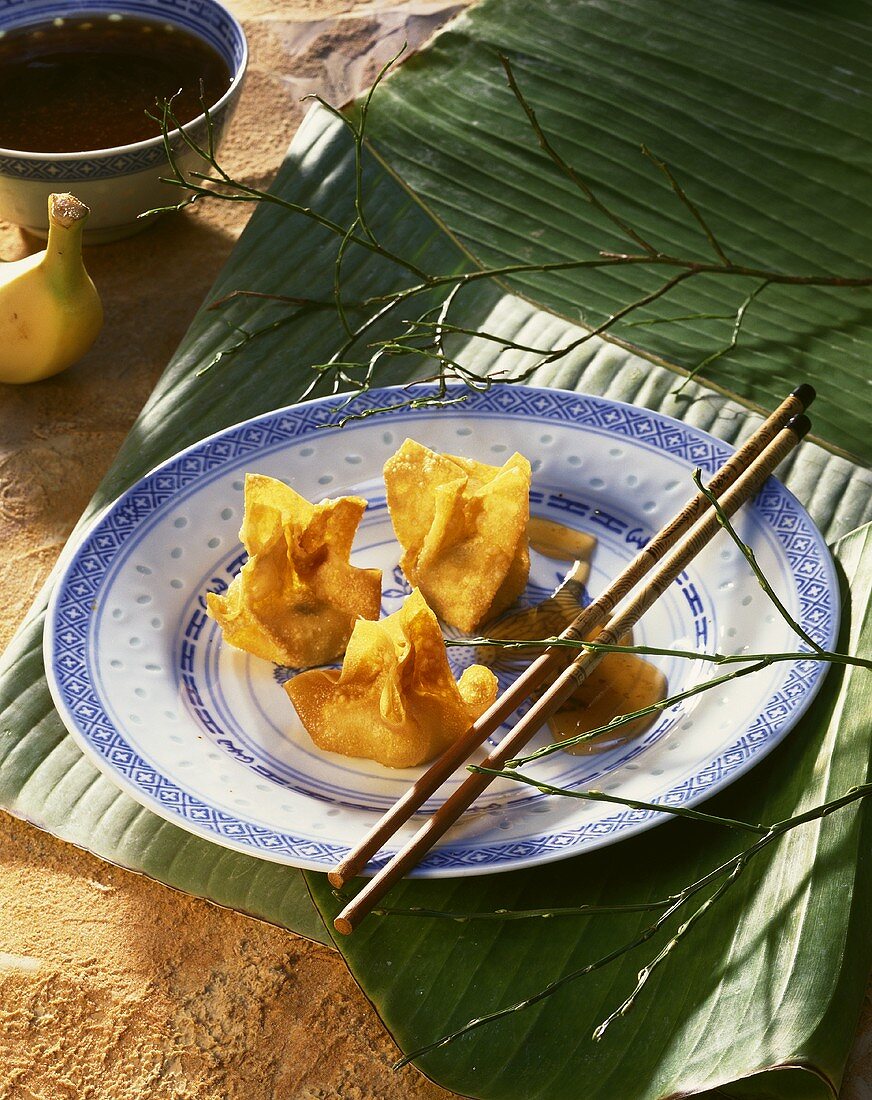Deep-fried pastry parcels with banana on Chinese plate