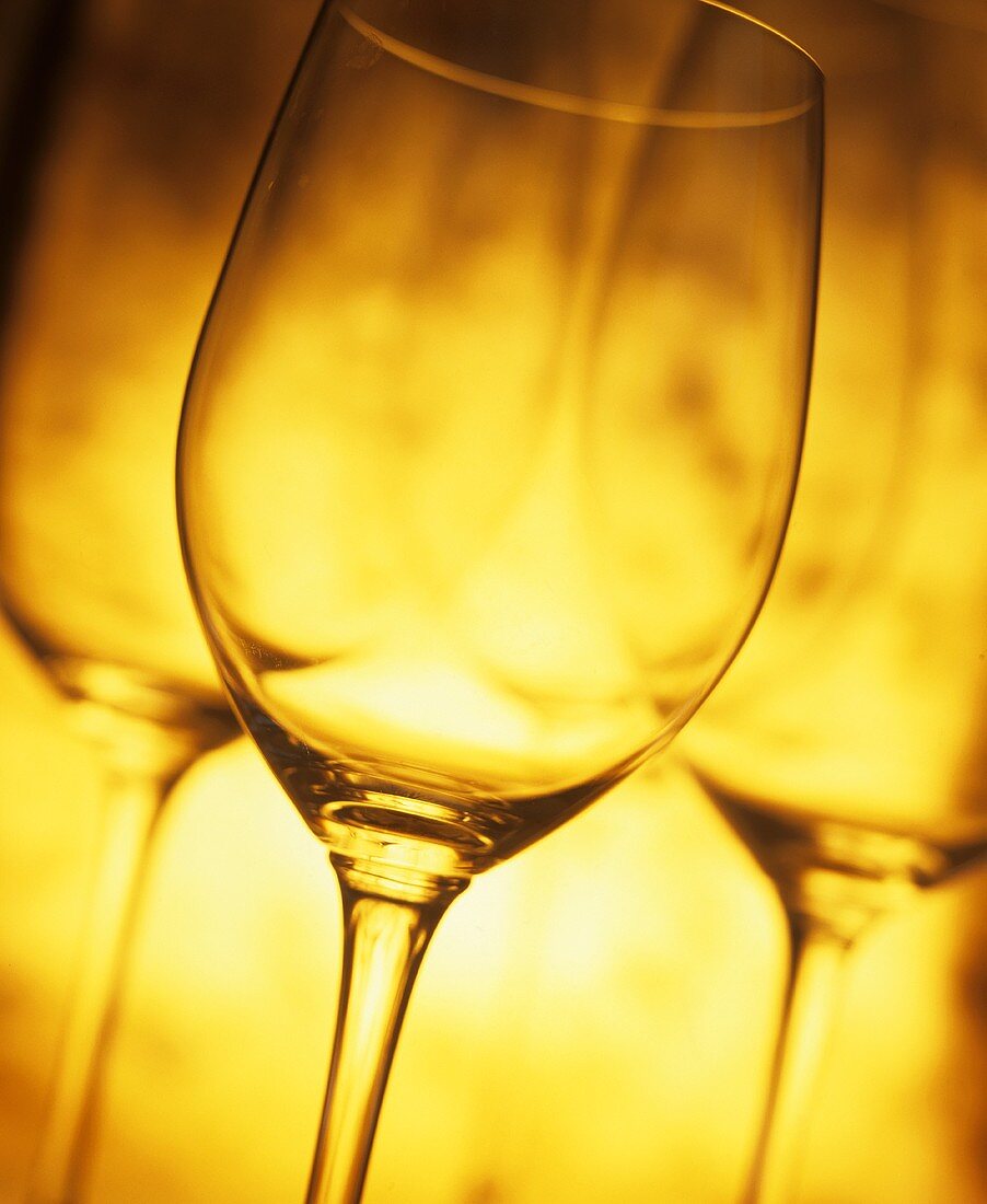 Empty wine glasses against a yellow backdrop