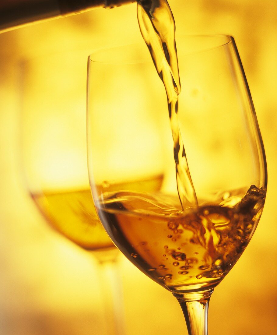 Pouring Pineau des Charentes (fortified wine) into a glass 