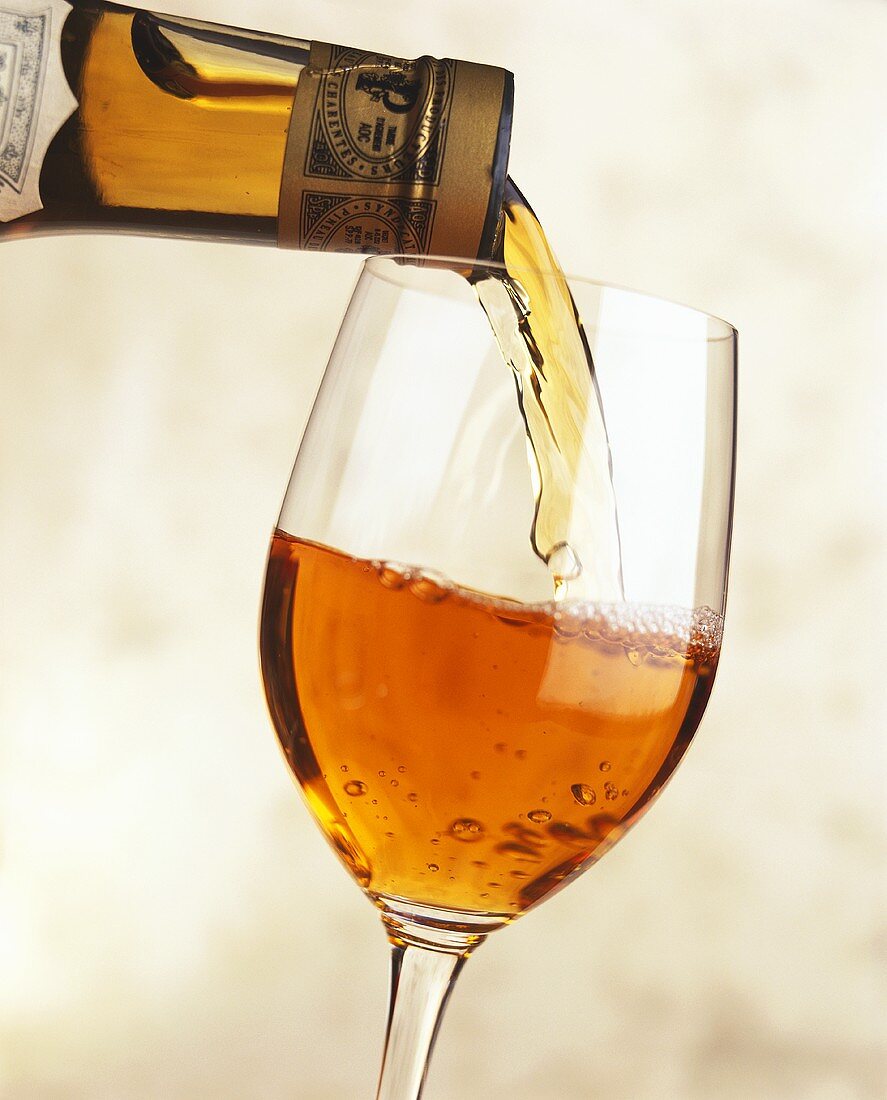 Pineau des Charentes aus Flasche in ein Glas einschenken