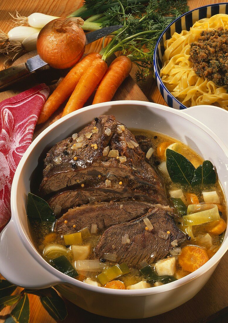 Braised pickled beef with vegetables in pot on chopping board